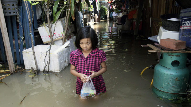 Thai girl walking through flood water